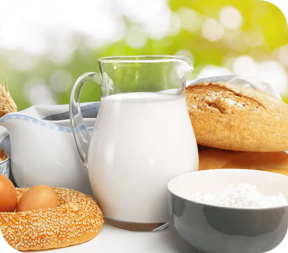 写真：左側に卵　中央に牛乳の入った瓶　右にパンと茶碗に入った白米